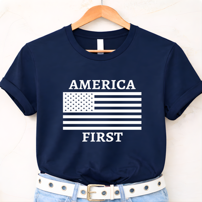 Navy blue t-shirt with 'AMERICA FIRST' graphic on a hanger against a white background