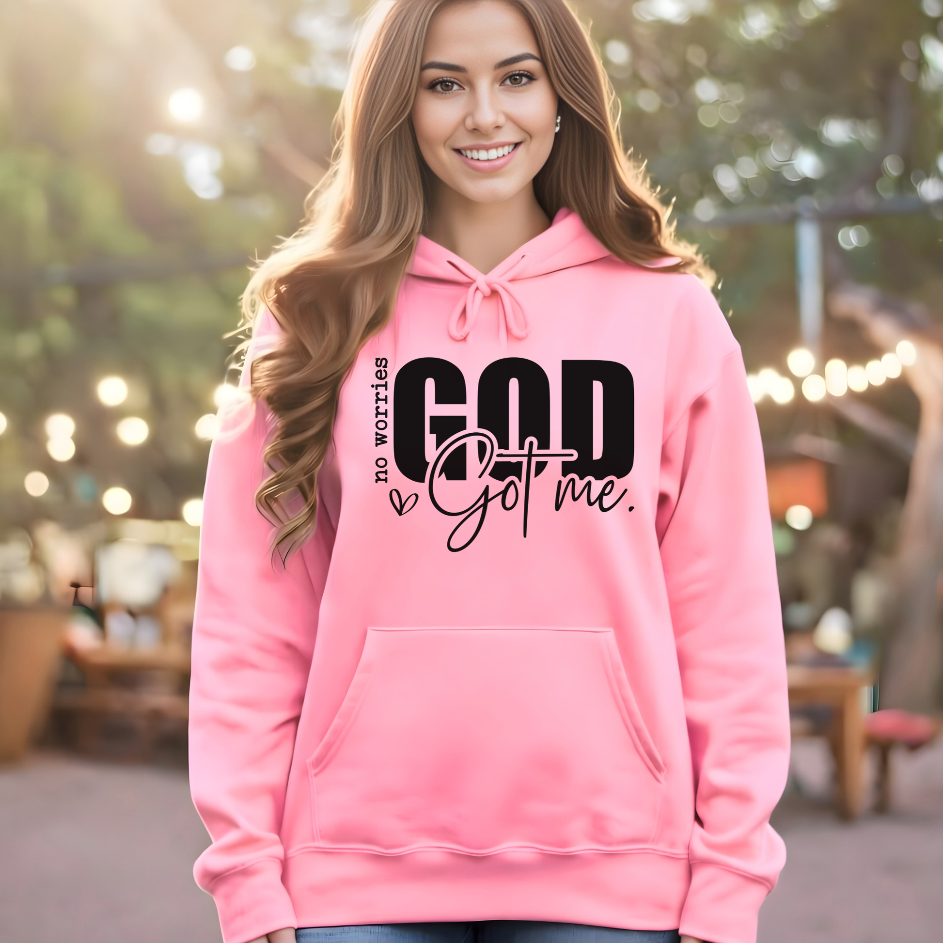 Woman wearing pink hoodie with No Worries God Got Me design