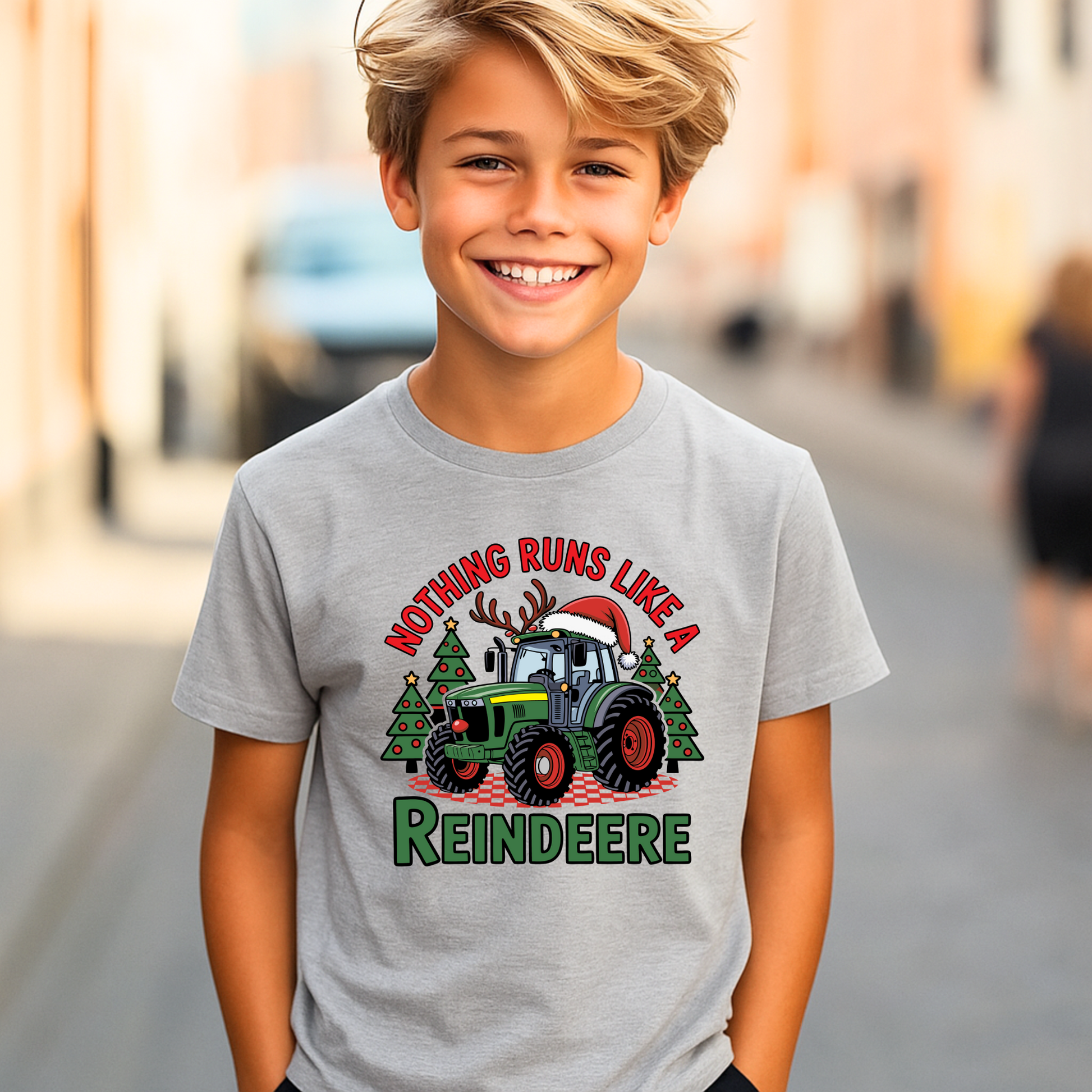 Gray youth Christmas tractor t-shirt with “Nothing Runs Like a Reindeere” festive design featuring green tractor, Santa hat, and Christmas trees. Perfect holiday shirt for farm kids.