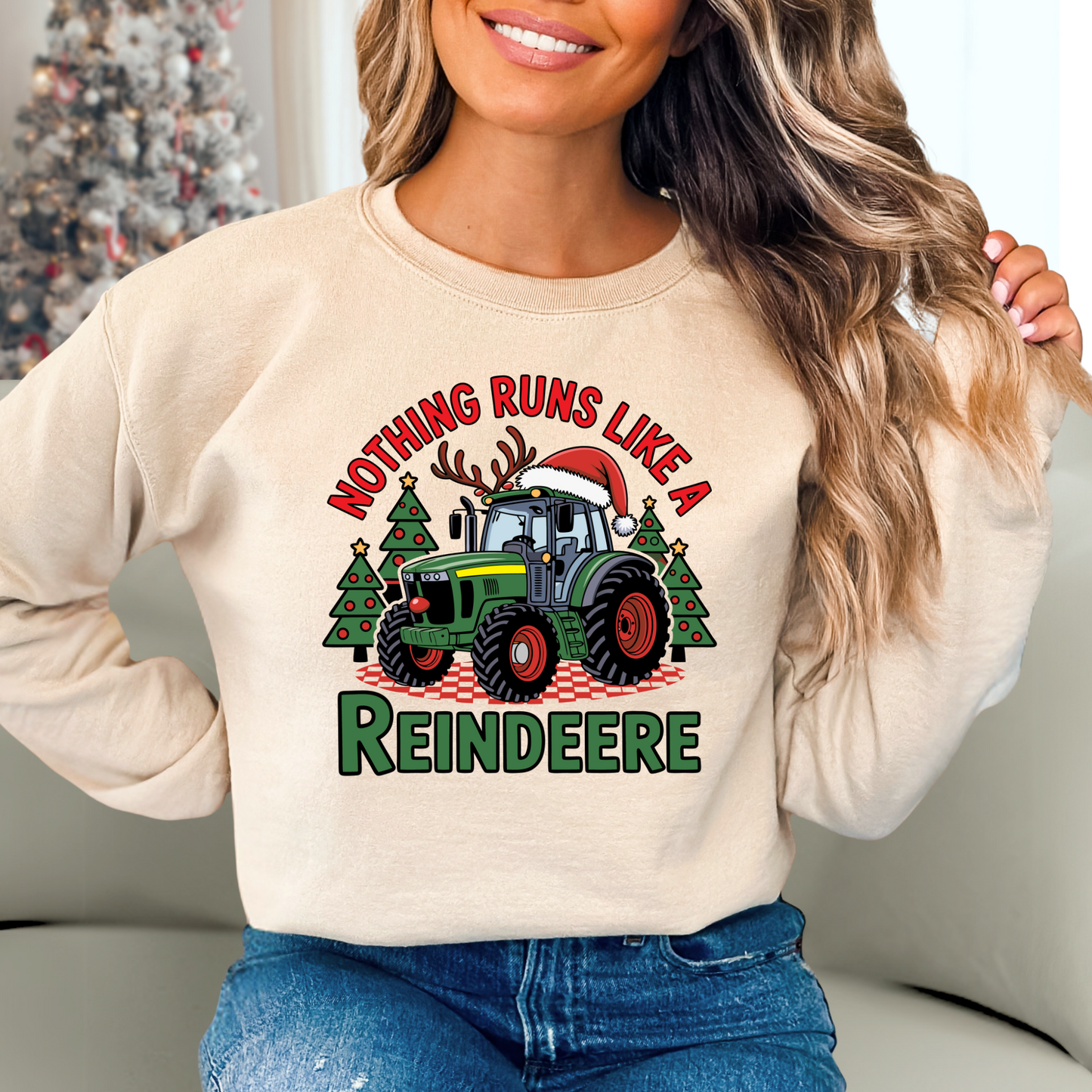Beige women’s Christmas tractor sweatshirt with “Nothing Runs Like a Reindeere” design, featuring festive green tractor, Santa hat, and Christmas trees. Cozy holiday farm sweater.