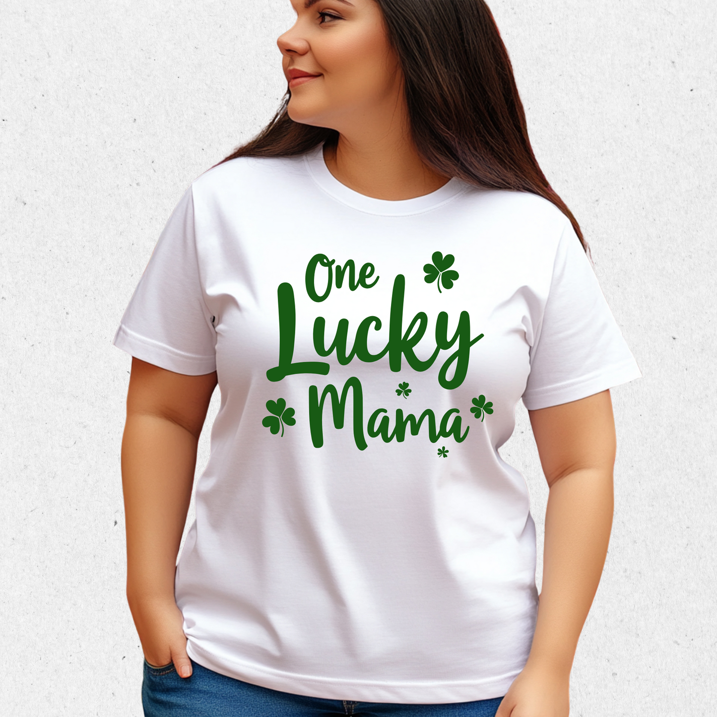 A stylish white t-shirt with "One Lucky Mama" in green script, decorated with shamrocks. Perfect for moms celebrating St. Patrick’s Day in a cute and festive way.