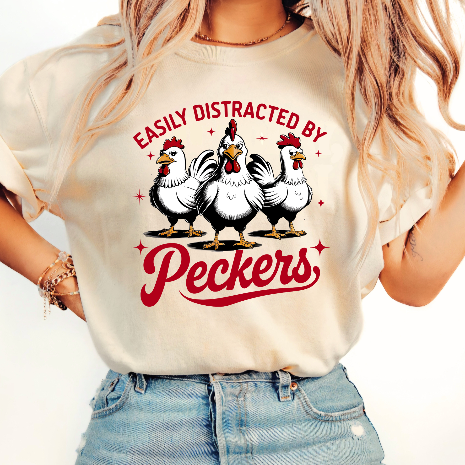 Person wearing a white t-shirt with cartoon chickens and text on a plain background