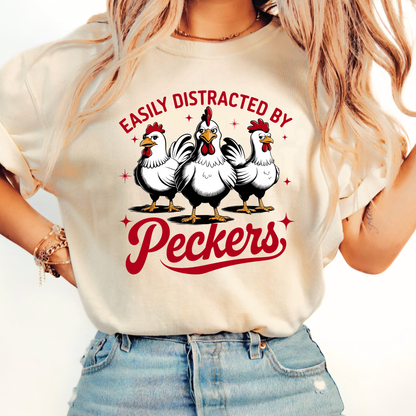 Person wearing a white t-shirt with cartoon chickens and text on a plain background