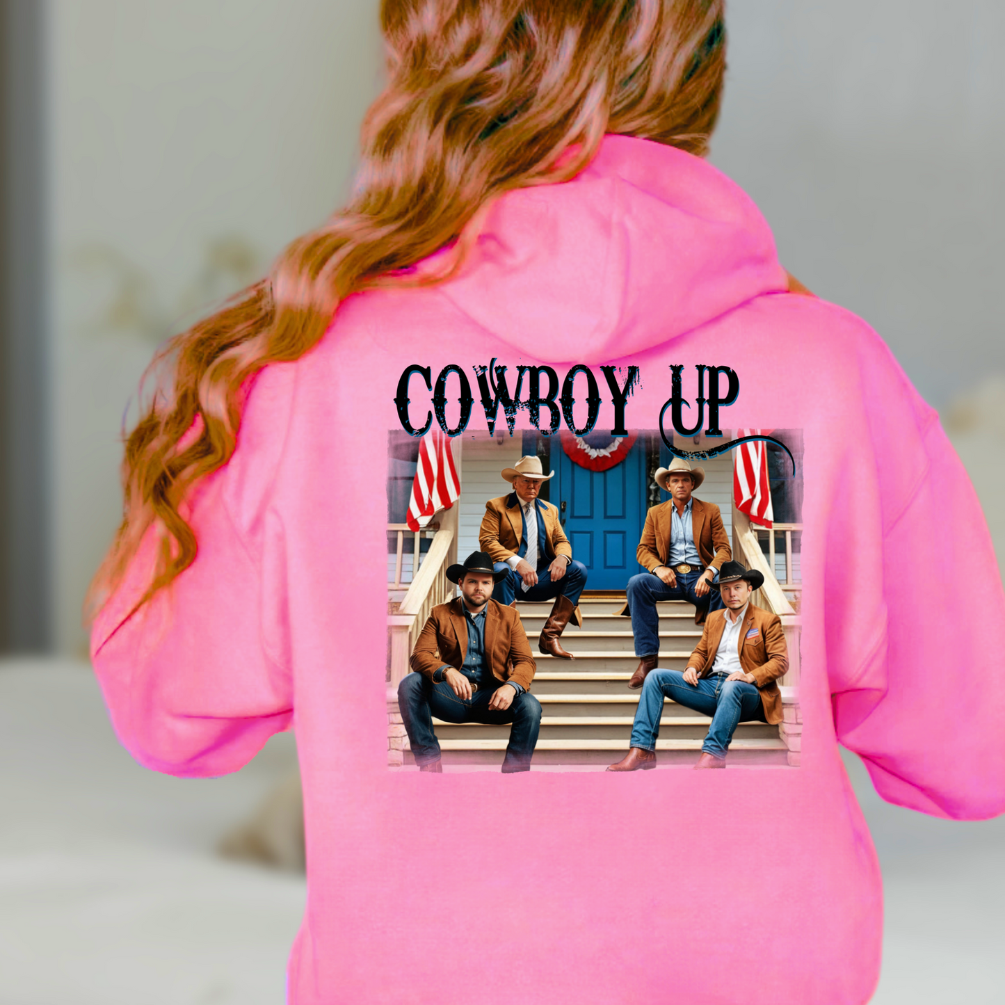 A white hoodie with a graphic print of cowboys seated on a porch with American flags and the text 'Cowboy Up' on the back and a front-left chest portrait of a cowboy with 'Cowboy Up' script.