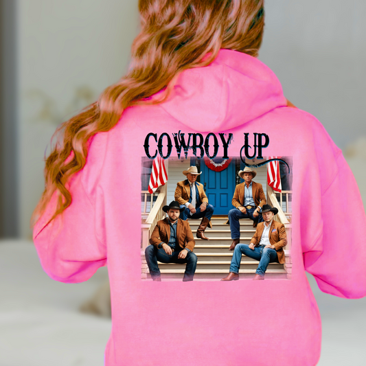 A white hoodie with a graphic print of cowboys seated on a porch with American flags and the text 'Cowboy Up' on the back and a front-left chest portrait of a cowboy with 'Cowboy Up' script.