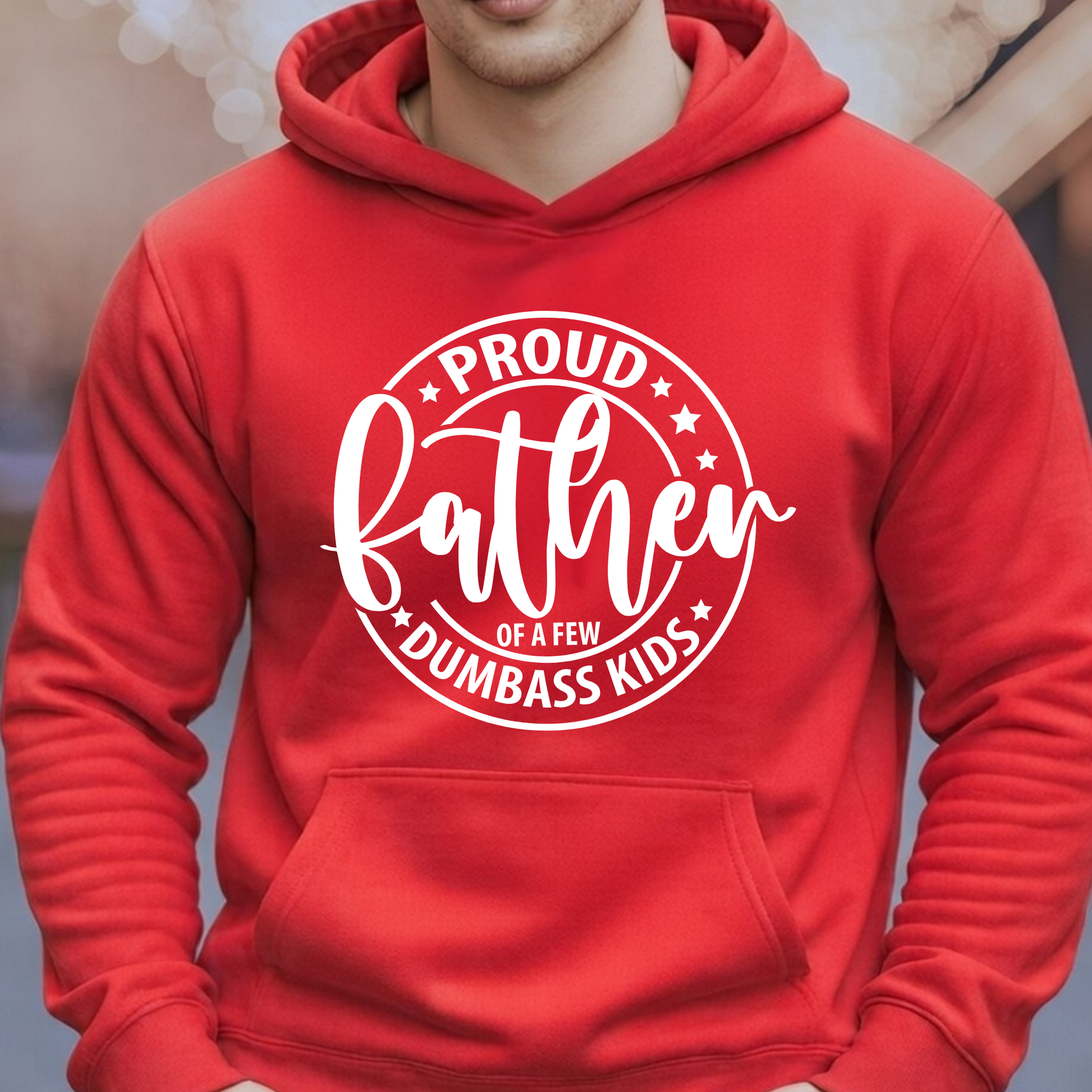 Red hoodie with white text 'Proud father of a few dumbass kids' on a blurred background