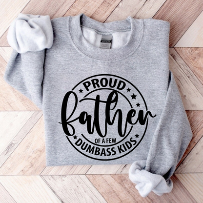 Gray sweatshirt with 'Proud father of a few dumbass kids' text on a wooden surface