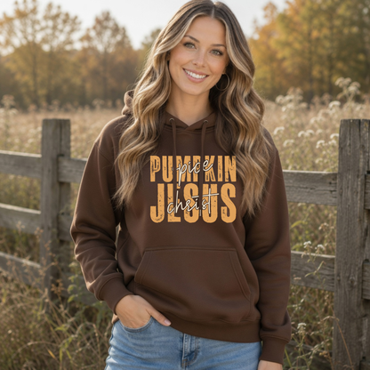 Woman in a brown Pumpkin Spice and Jesus Christ hoodie posed outdoors with golden fall foliage
