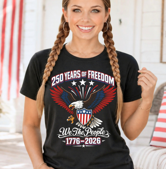Woman wearing a black t-shirt with a patriotic design featuring an eagle and text about 250 years of freedom.