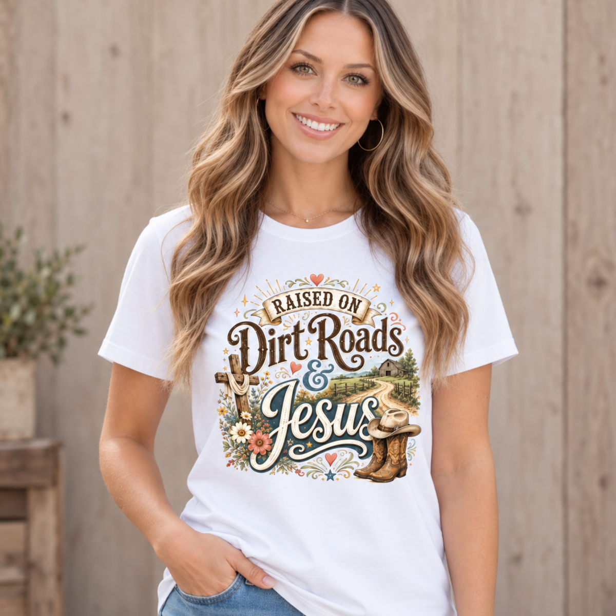 Woman wearing a white Raised on Dirt Roads & Jesus crewneck T-Shirt by a rustic fence.