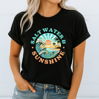 Woman in black Salt Water & Sunshine T-shirt with wave and sunset design, casual summer look

