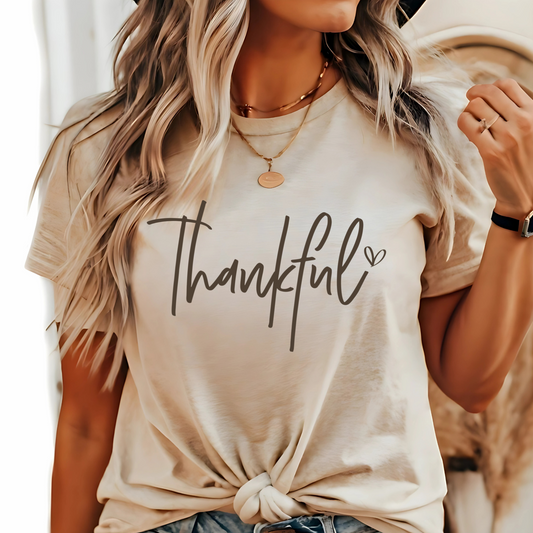 Beige t-shirt with 'Thankful' text worn by a woman