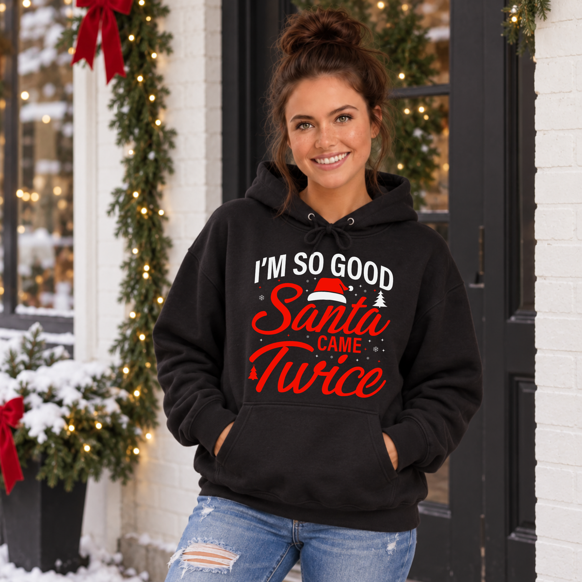 Woman wearing a black hoodie with the funny I'm So Good Santa Came Twice holiday design.