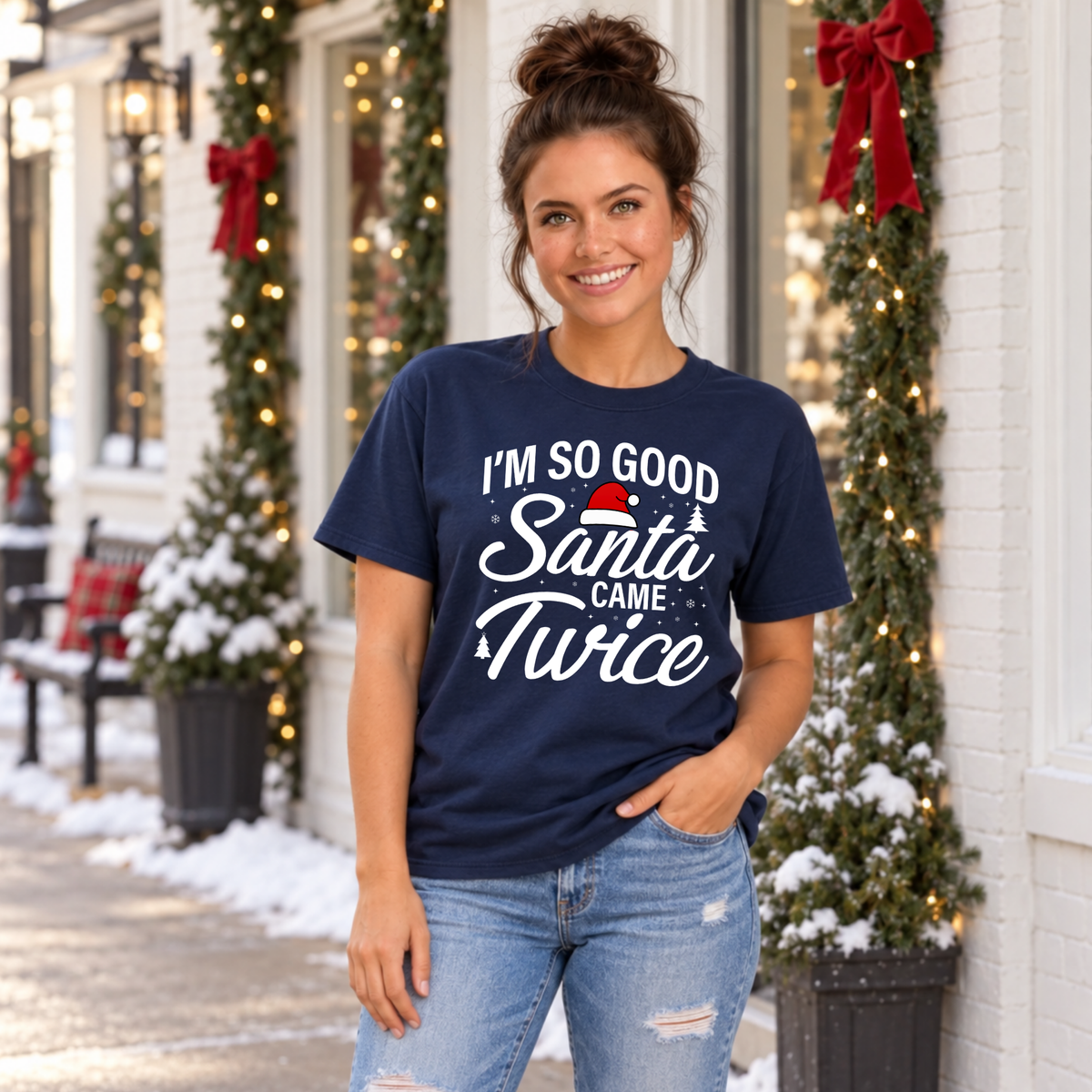 Woman wearing a navy T-shirt with the funny I'm So Good Santa Came Twice holiday design.