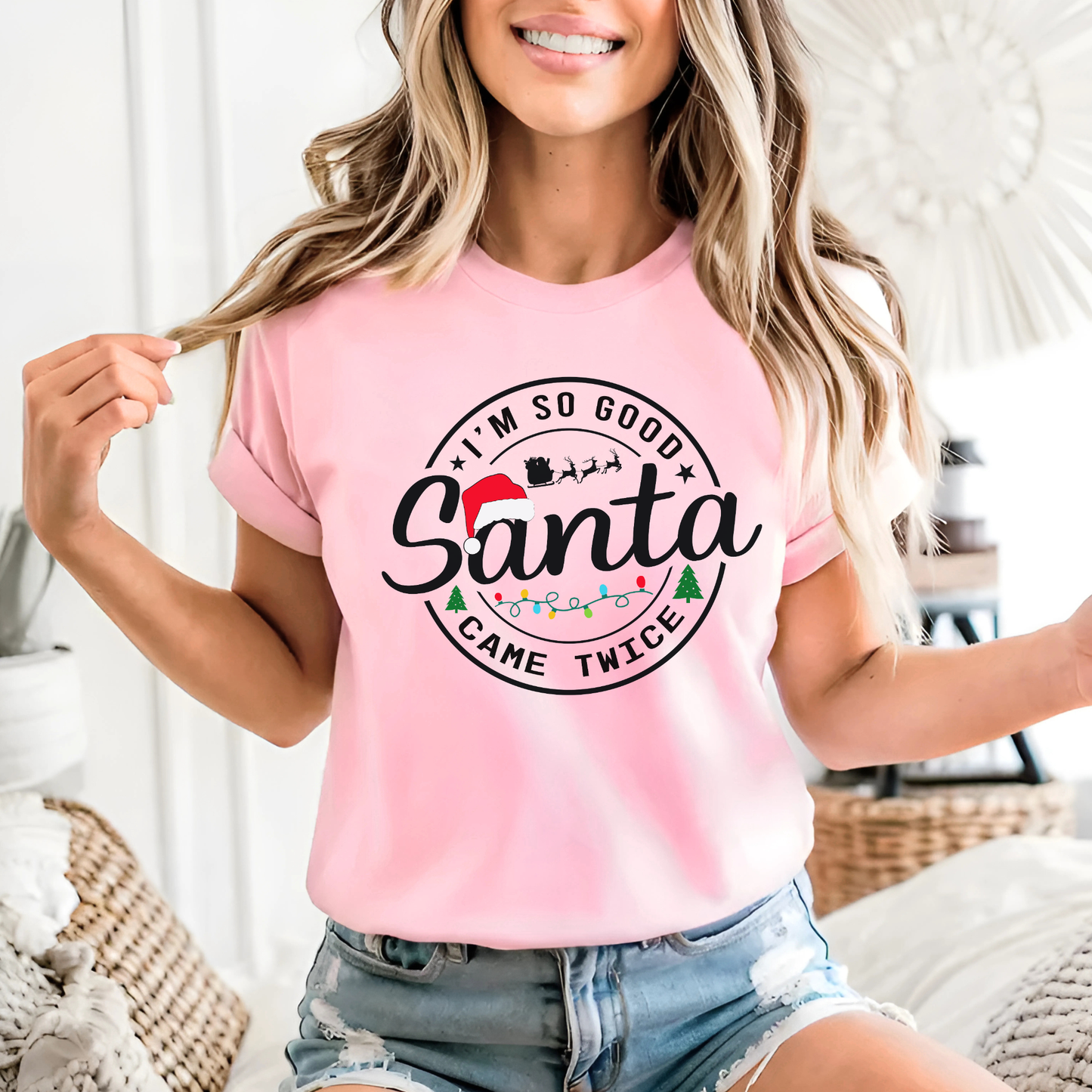 Person wearing a pink t-shirt with 'I'm so good Santa came twice' text