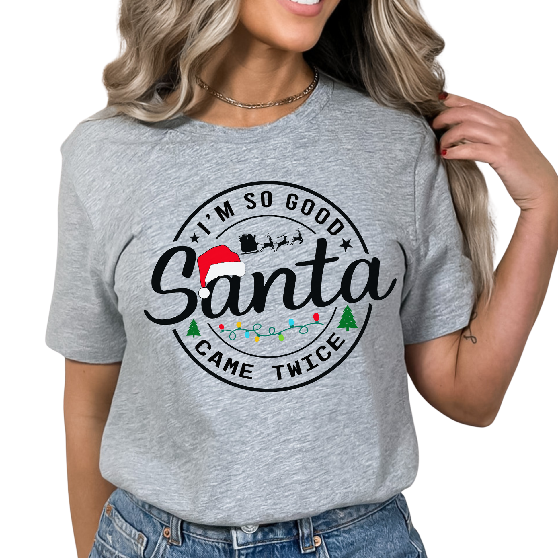 Gray t-shirt with Christmas-themed text and graphics worn by a person on a white background