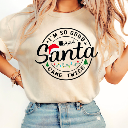 Woman wearing a cream t-shirt with 'I'm so good Santa came twice' text and graphics.