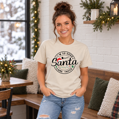 Woman wearing a sand T-shirt with I'm So Good Santa Came Twice Christmas design in a festive café