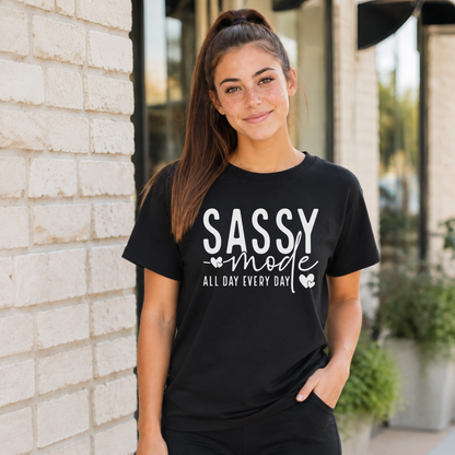 Woman wearing a black Sassy Mode T-shirt with white lettering outside a storefront.