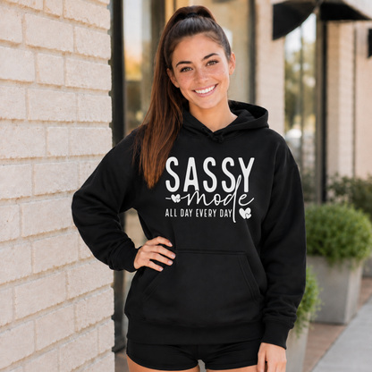 Woman wearing a black Sassy Mode hoodie with white lettering outside a storefront.