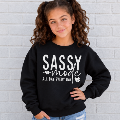 Youth girl wearing a black Sassy Mode sweatshirt with white lettering outside a storefront.