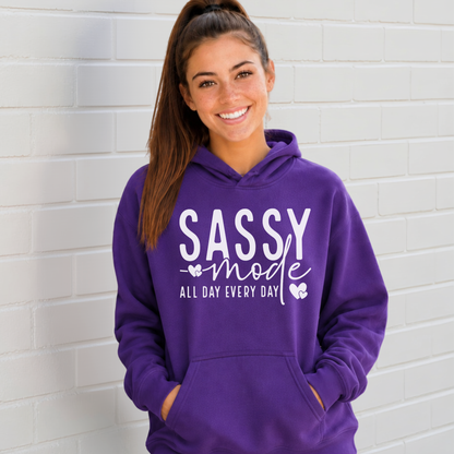 Woman wearing a purple Sassy Mode hoodie with white lettering outside a storefront.