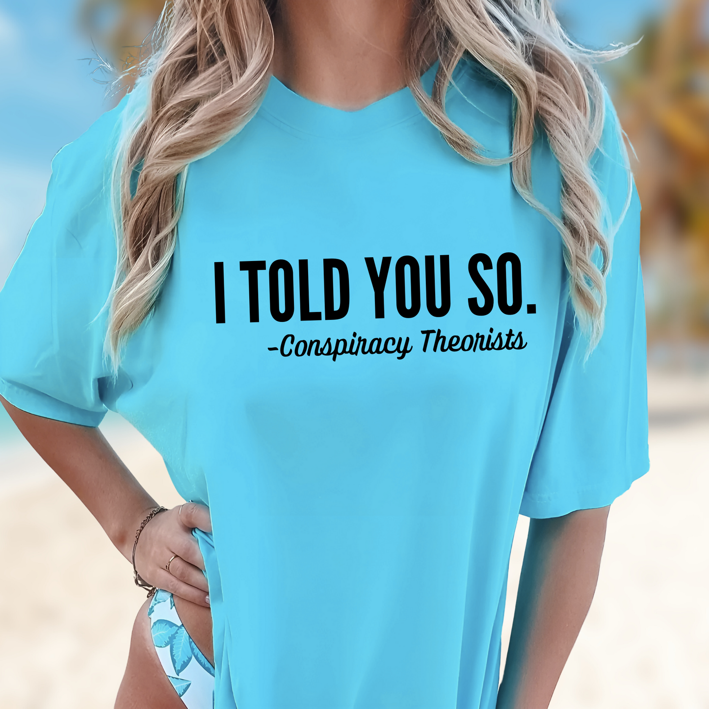 Sky blue shirt styled on beach background. "I told you so - Conspiracy Theorists" 