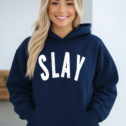 Woman wearing a navy hoodie with 'SLAY' text on a plain background