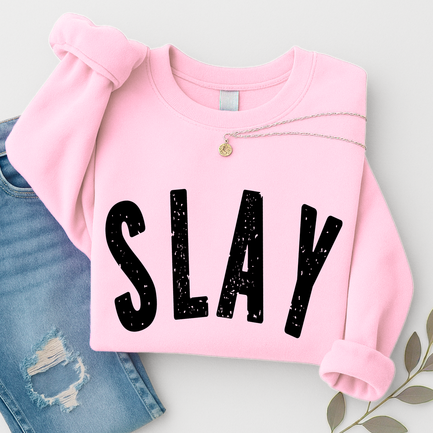 Pink sweatshirt with 'SLAY' text on a light gray background