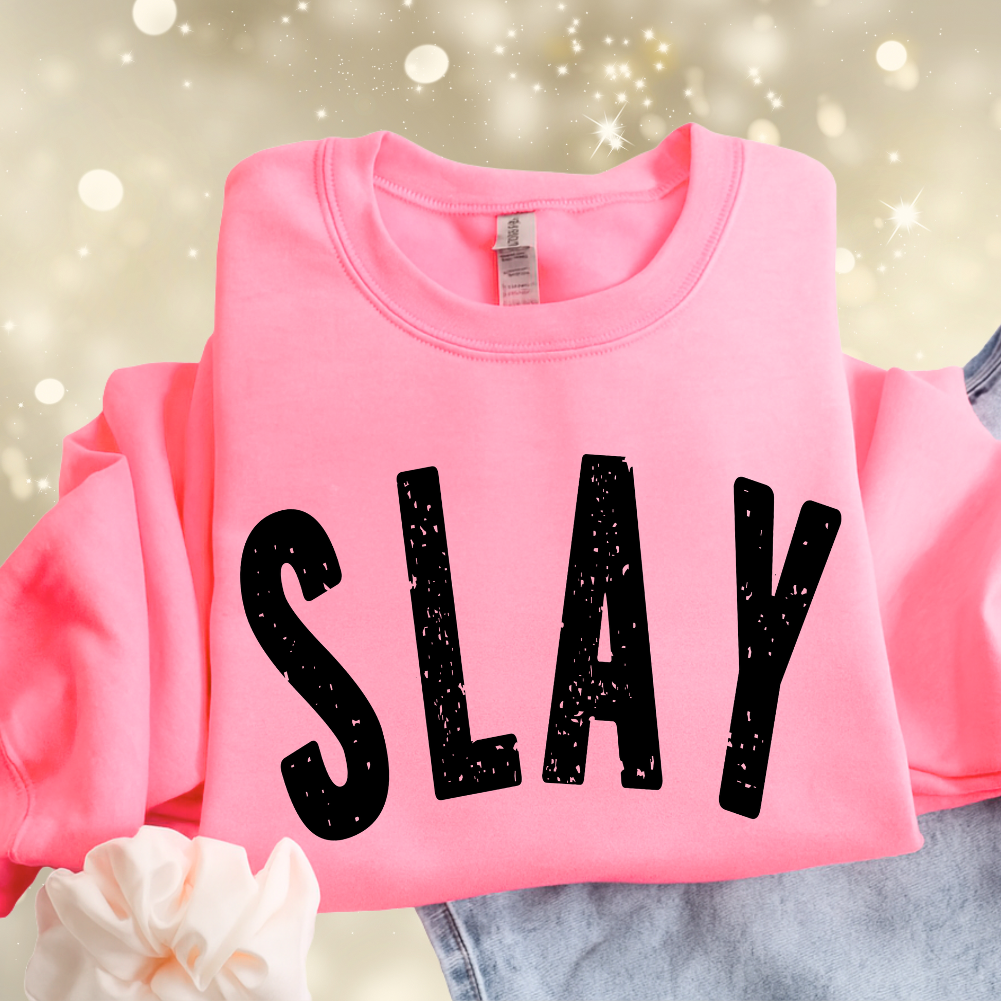 Pink sweatshirt with 'SLAY' text on a blurred background