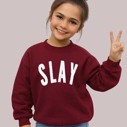 Girl wearing maroon SLAY sweatshirt giving peace sign