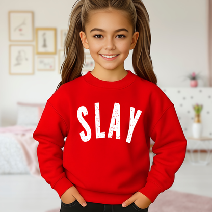 Girl modeling red SLAY youth sweatshirt in bedroom