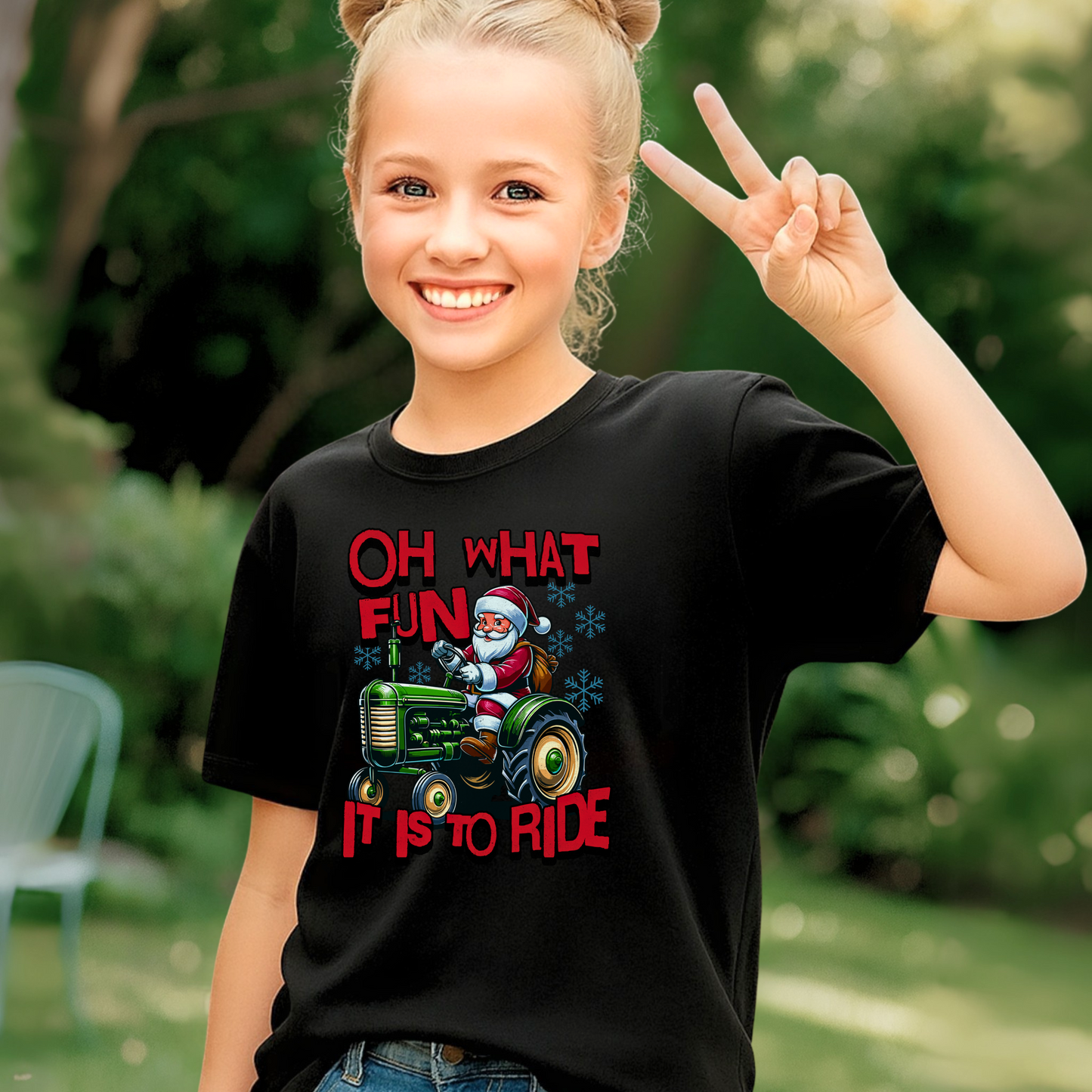 Smiling girl outdoors wearing a black Christmas tractor T-shirt with Santa Claus and red holiday text.