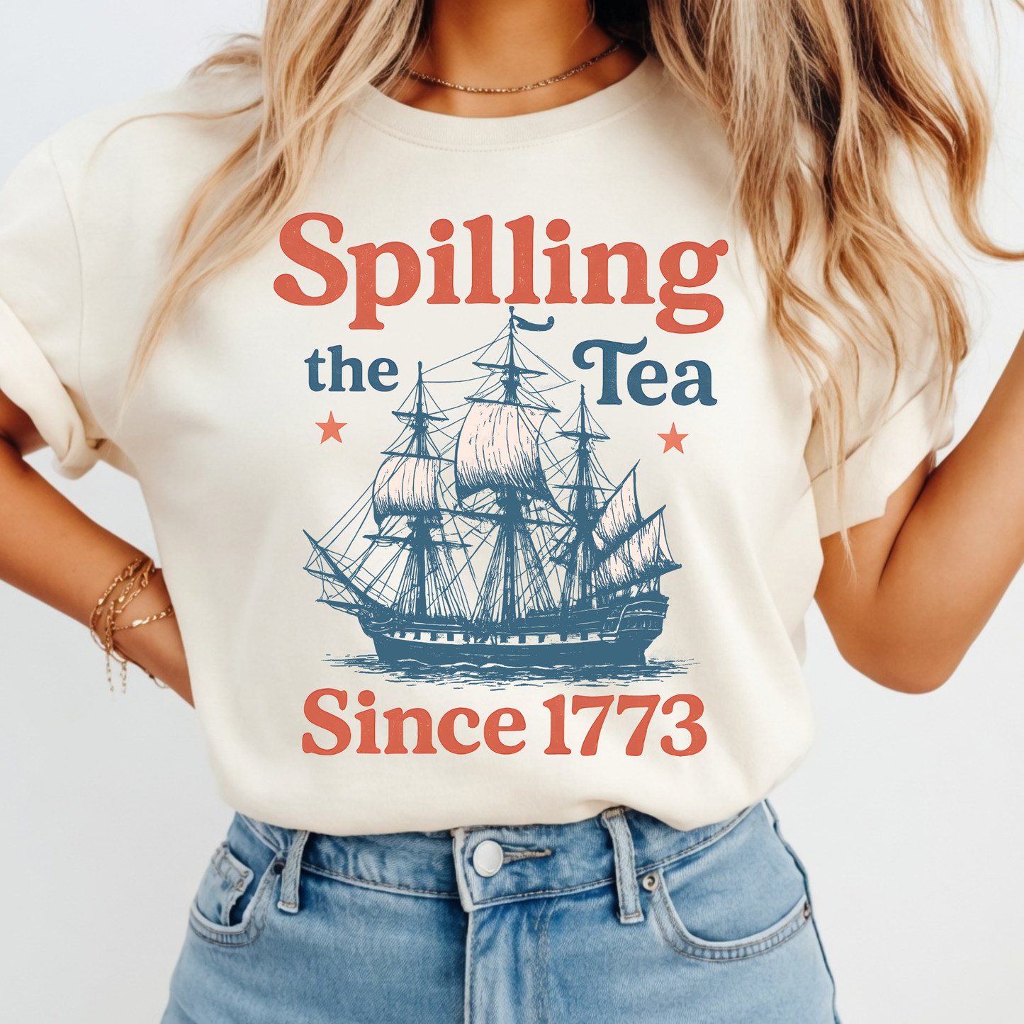 Woman wearing a t-shirt with a ship graphic and text 'Spilling the Tea Since 1773' on a plain background