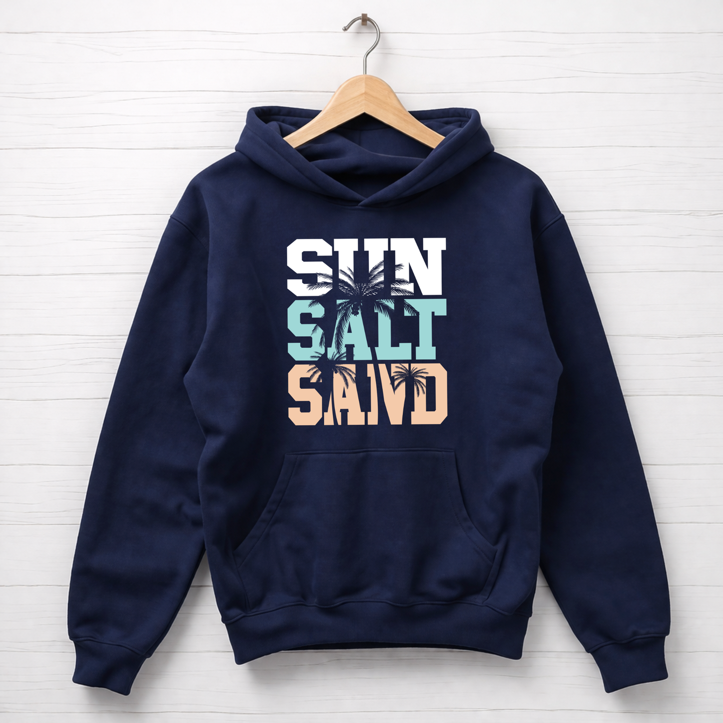 Navy blue hoodie with 'Sun Salt Sand' text and palm tree graphics on a white wooden background