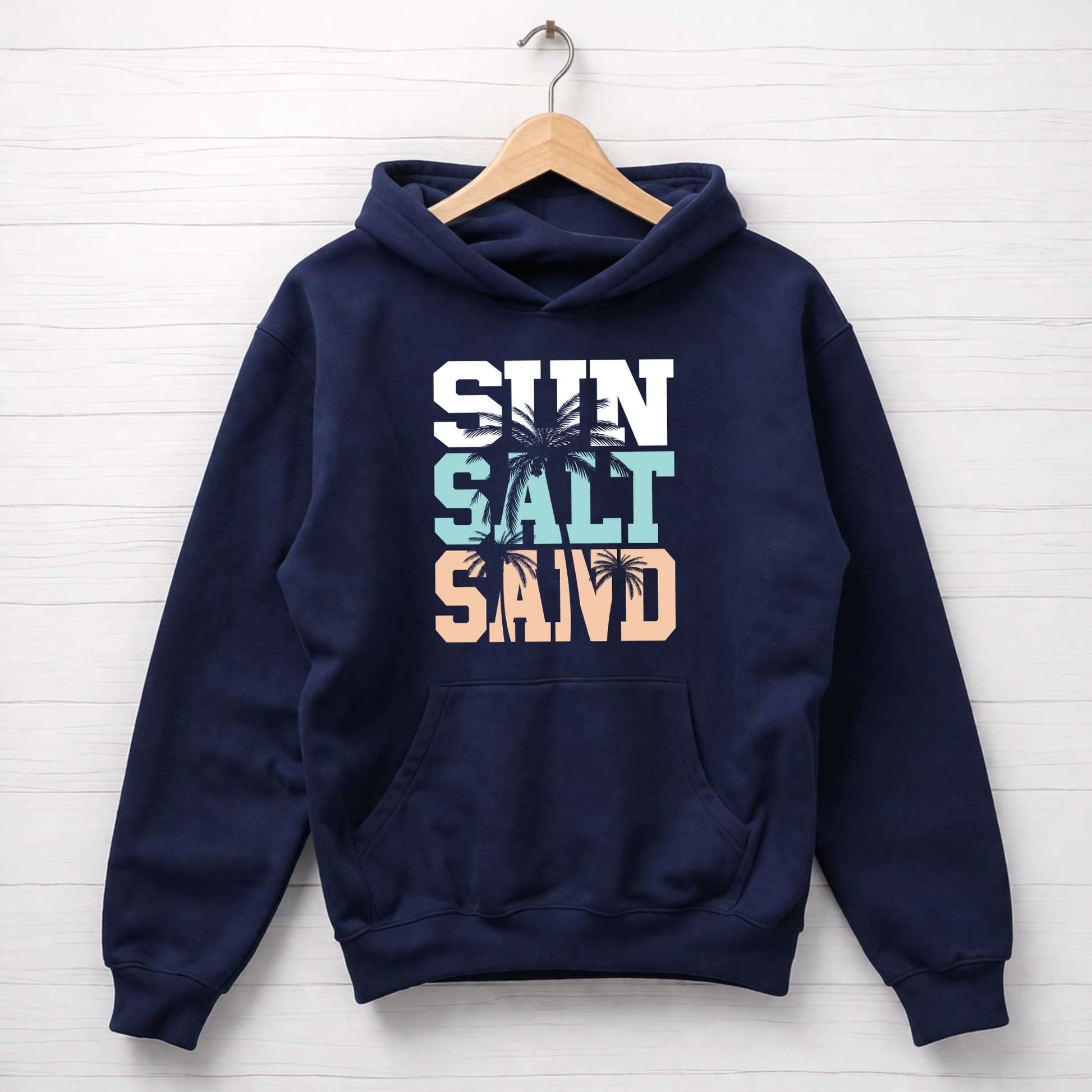 Navy blue hoodie with 'Sun Salt Sand' text and palm tree graphics on a white wooden background