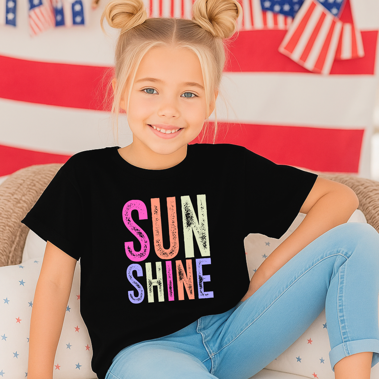 Girl in pink room wearing “Sunshine” tee and jeans

