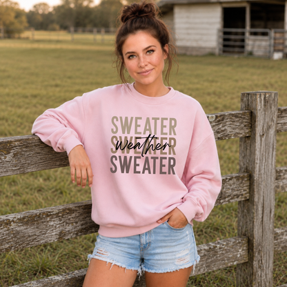 Woman outdoors wearing a light pink “Sweater Weather Sweater” crewneck sweatshirt with denim shorts.