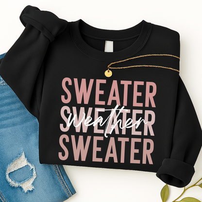 Black Sweater Weather sweatshirt folded with gold necklace and jeans. Cozy unisex fall crewneck perfect for women’s casual outfits and winter layering