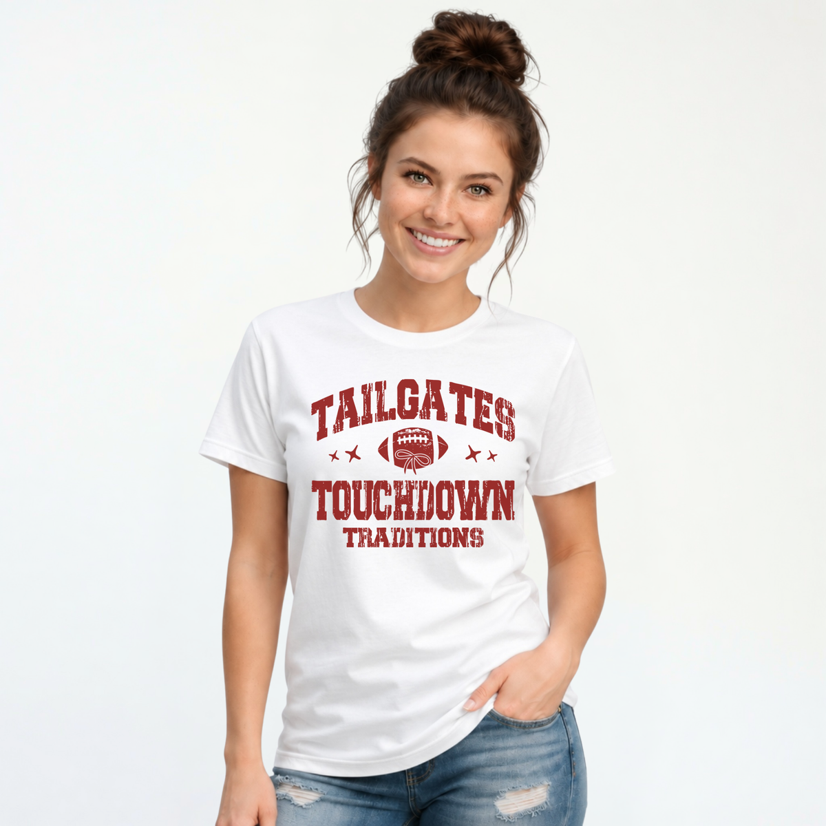 Smiling woman models a white T-shirt with the red Tailgates & Touchdown Traditions football design against a clean studio background.