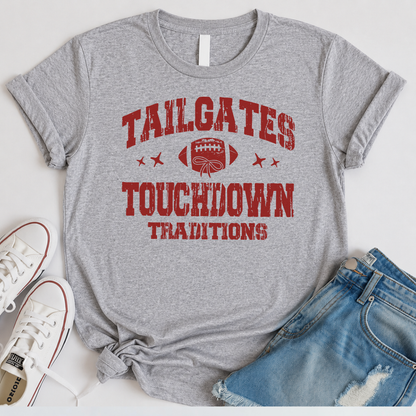Sports gray T-shirt flat lay with the Tailgates & Touchdown Traditions design, distressed jeans, and white sneakers.