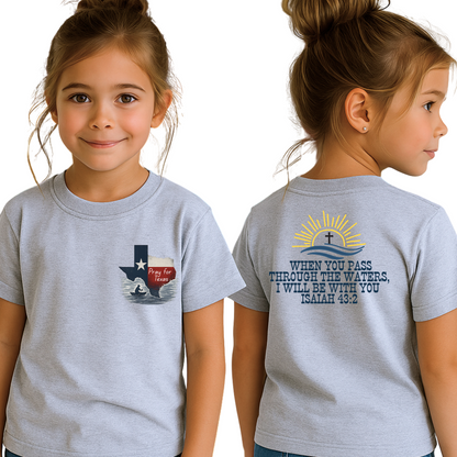 Young girl in light gray “Pray for Texas” Christian t-shirt featuring Texas state with flood waters and small figure praying, back displays Isaiah 43:2 scripture quote with sunrise and cross, faith apparel for kids