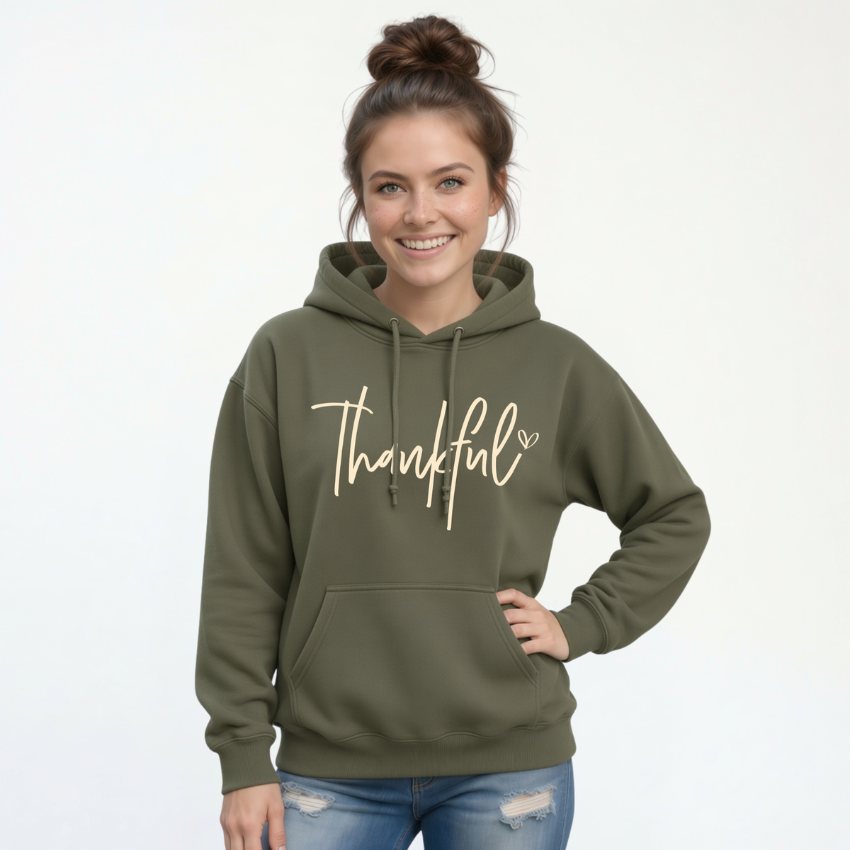 Woman modeling a military green pullover hoodie with a white Thankful script design on a white background