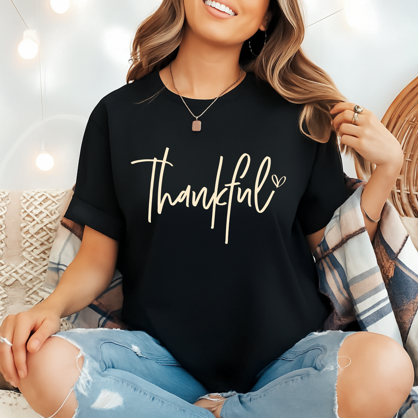 Woman wearing black “Thankful” tee with jeans and cardigan