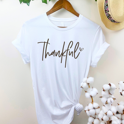 White “Thankful” shirt hanging on wooden hanger for Thanksgiving