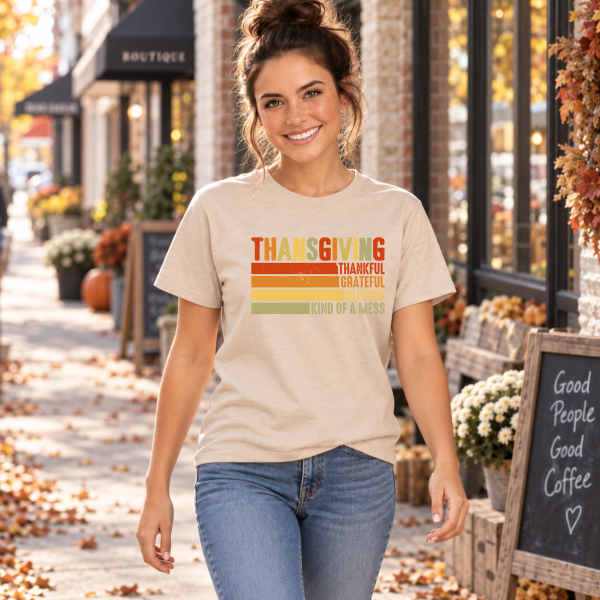 Woman walking outside a fall storefront in a sand T-shirt with retro Thanksgiving Kind of a Mess design.