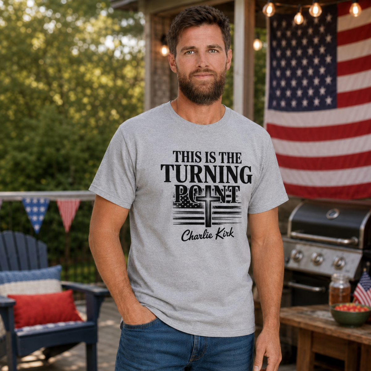 Man wearing a sports gray T-shirt with black This Is the Turning Point cross graphic in a patriotic backyard setting.