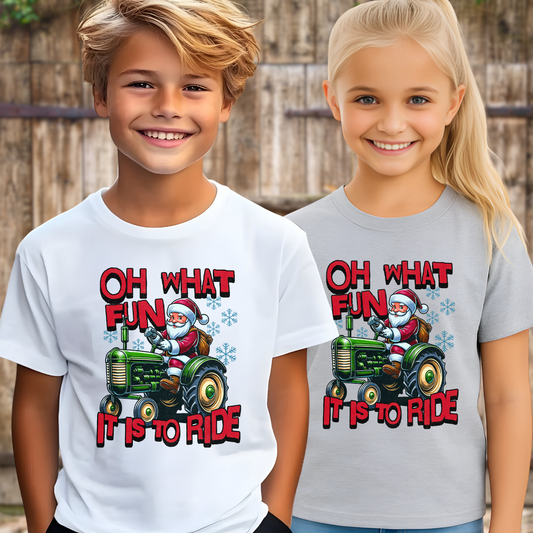 Two children wearing t-shirts with a Christmas design of Santa driving a tractor and text.