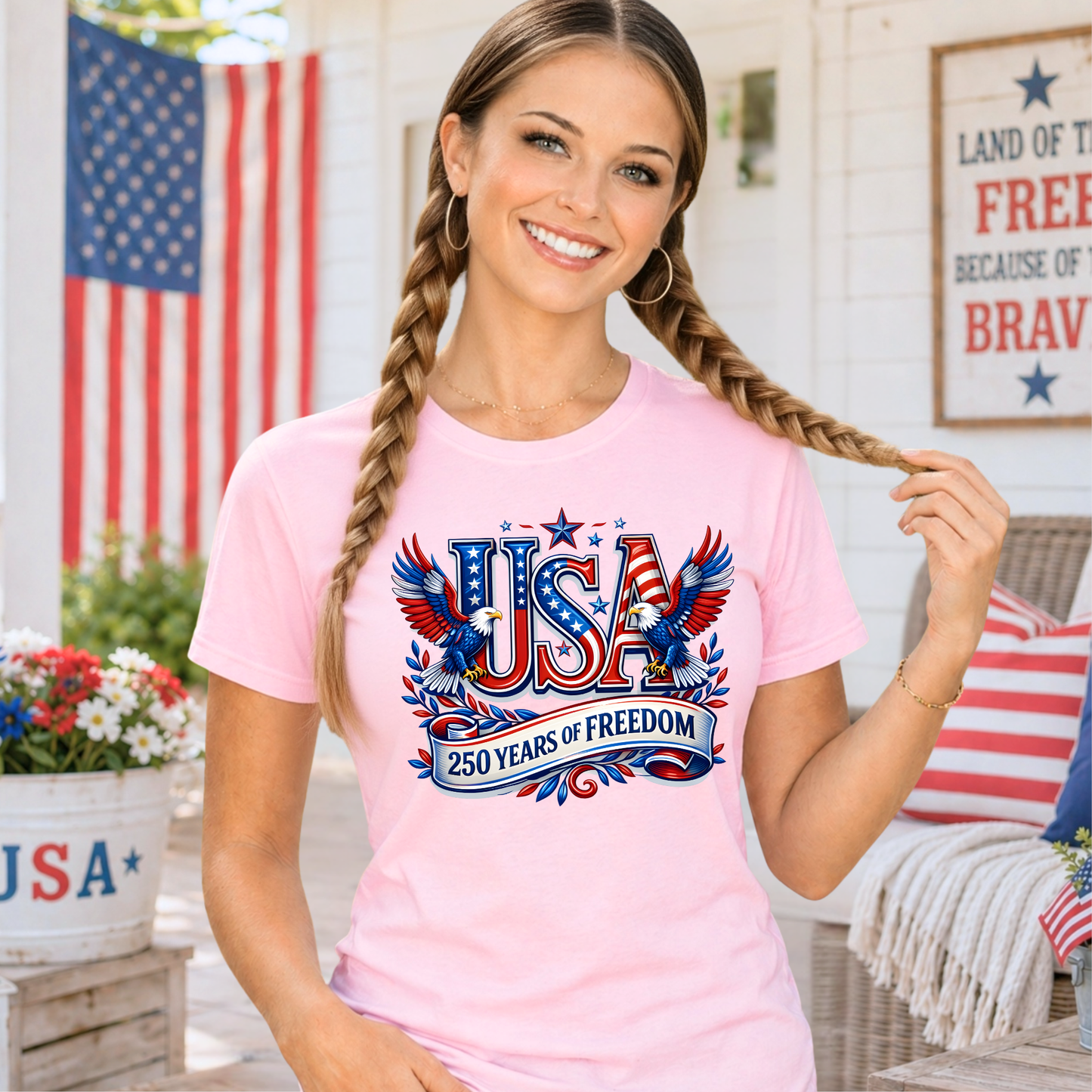 Woman wearing a pink t-shirt with 'USA 250 Years of Freedom' design, standing in a patriotic setting.