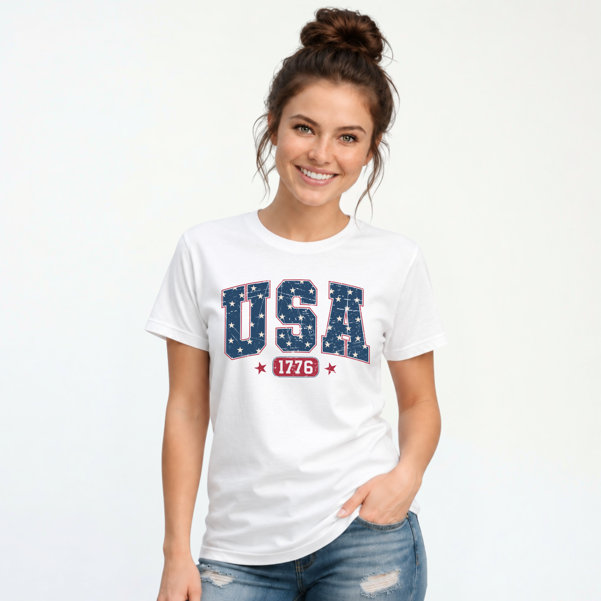 Smiling woman in a white T-shirt with a navy USA graphic filled with white stars and red 1776 lettering